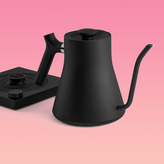 A black & stainless steel pour-over kettle with a gooseneck spout and a black handle, sitting on a black base.