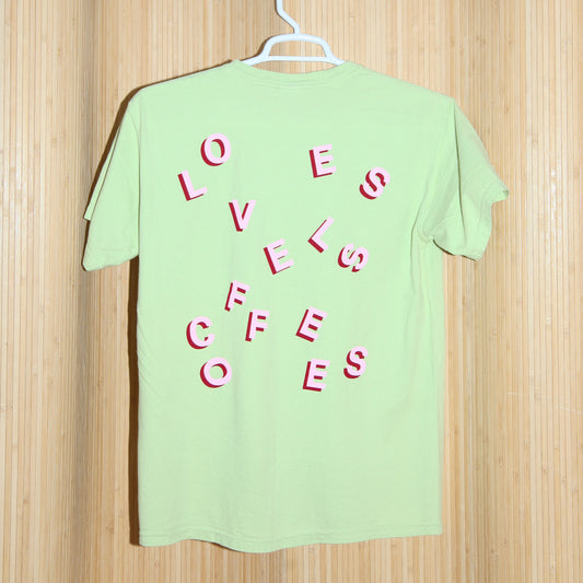 Light green T-shirt with stylized 'LOVELESS COFFEES' text in pink and red with a bamboo background