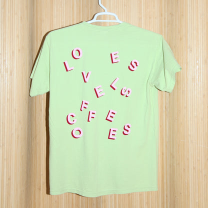 Light green T-shirt with stylized 'LOVELESS COFFEES' text in pink and red with a bamboo background